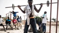 Un jeune enfant de la rue, également appelé Talibe, joue à soulever des poids en zone de quarantaine, dans un refuge pour enfants de rue nouvellement arrivés à l'extérieur de Dakar, le 10 avril 2020.