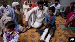 Fahd Ali, 10, right, who was injured in a bombing that killed his parents and sister and wounded two sisters, narrates his ordeal to visitors outside his home in Lahore, Pakistan, Monday, March 28, 2016. Pakistan's prime minister on Monday vowed to eliminate perpetrators of terror attacks such as the massive suicide bombing that targeted Christians gathered for Easter the previous day in the eastern city of Lahore, killing 70 people. (AP Photo/B.K. Bangash)