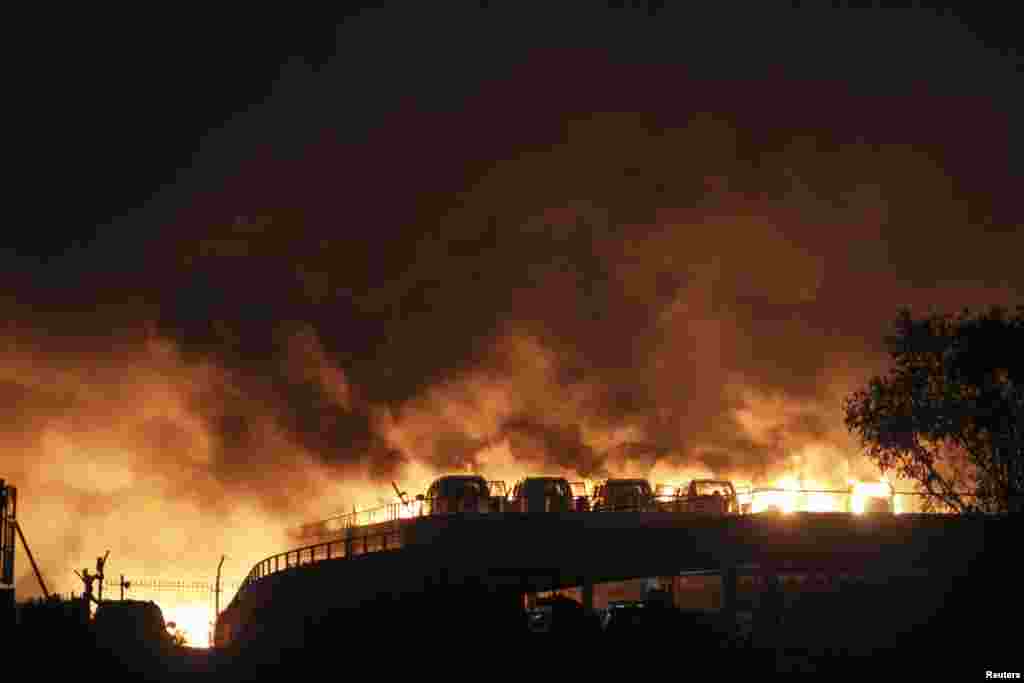 Vehicles are seen burning after blasts in the Binhai district of Tianjin, China, Aug. 13, 2015.