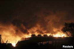 Vehicles are seen burning after blasts in the Binhai district of Tianjin, China, August 13, 2015.