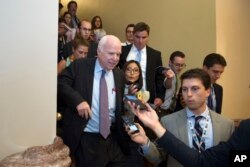 Sen. John McCain, Republican-Arizona, front left, is pursued by reporters after casting a "no" vote on a measure to repeal parts of former president Barack Obama's health care law, on Capitol Hill in Washington, July 28, 2017.