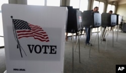 FILE - Voters cast ballots in Hinsdale, Ill., March 18, 2014.