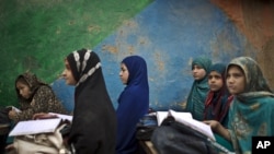 FILE - Afghan refugee schoolgirls attend a class at a makeshift school on the outskirts of Islamabad, Pakistan, Feb. 23, 2015.