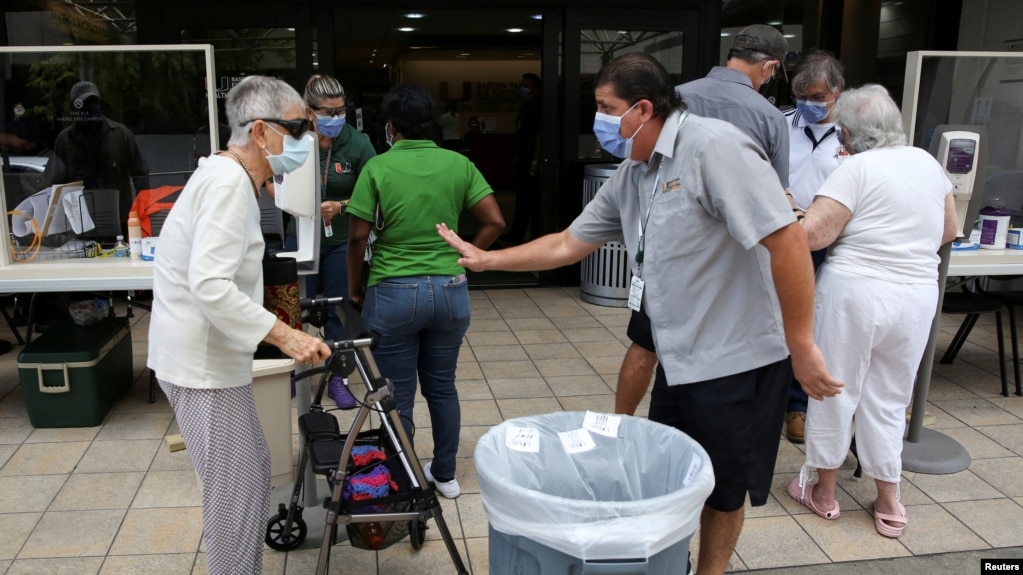 Người dân được kiểm tra sức khỏe trước khi được cho vào bệnh viện Jackson Memorial ở Florida.