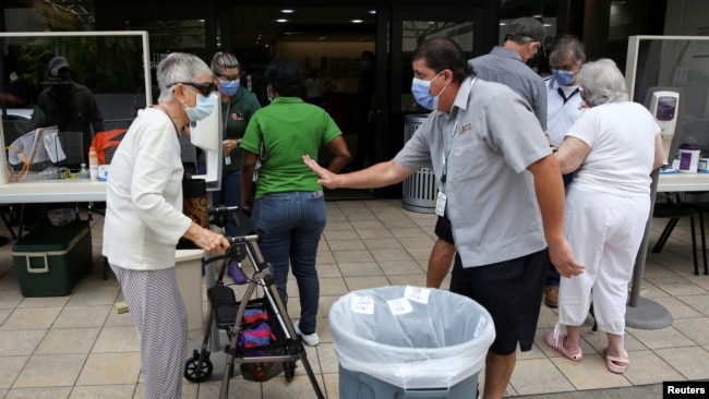 Người dân được kiểm tra sức khỏe trước khi được cho vào bệnh viện Jackson Memorial ở Florida.