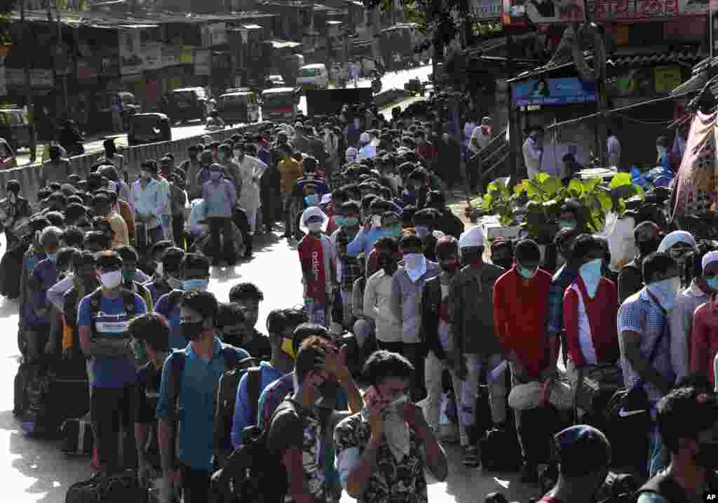 Migrant workers line up to board buses for their trip back to their home states, at Dharavi, one of Asia&#39;s largest slums, in Mumbai, India.