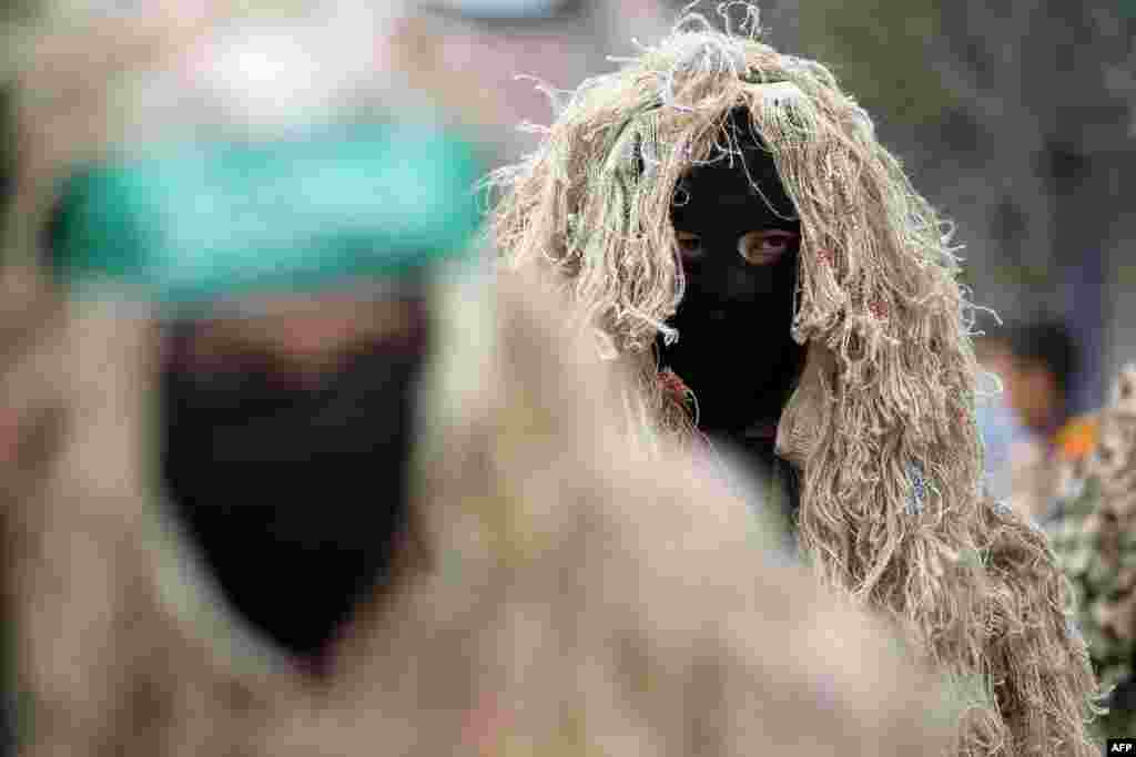 Palestinian militants from the Ezzedine al-Qassam brigade, the armed wing of Hamas, march during a rally to commemorate the 27th anniversary of the Islamist movement’s creation, at the Nuseirat refugee camp in the Central Gaza Strip.