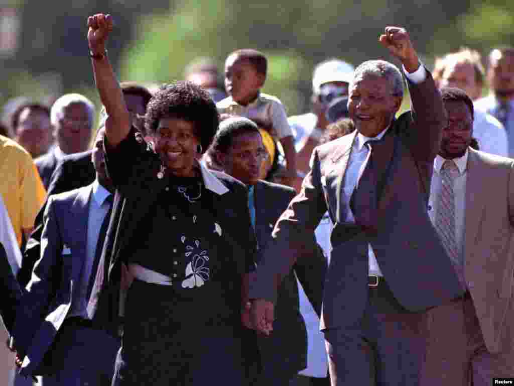 Nelson Mandela na aliyekuwa mke wake wa kwanza, Winnie, wakiwapungia mkono walojitokeza kumkaribisha akitoka kutoka jela ya Victor Verster hapo Febuari 11, 1990. 