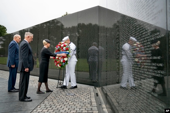 Cindy McCain, wife of Sen. John McCain, accompanied by President Donald Trump's Chief of Staff John Kelly (L) and Defense Secretary Jim Mattis (2-L) lays a wreath at the Vietnam Veterans Memorial in Washington, Sept. 1, 2018.