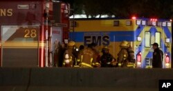 Firefighters stage near the area where a suspect in a series of bombing attacks in Austin blew himself up as authorities closed in, early March 21, 2018, in Round Rock, Texas.