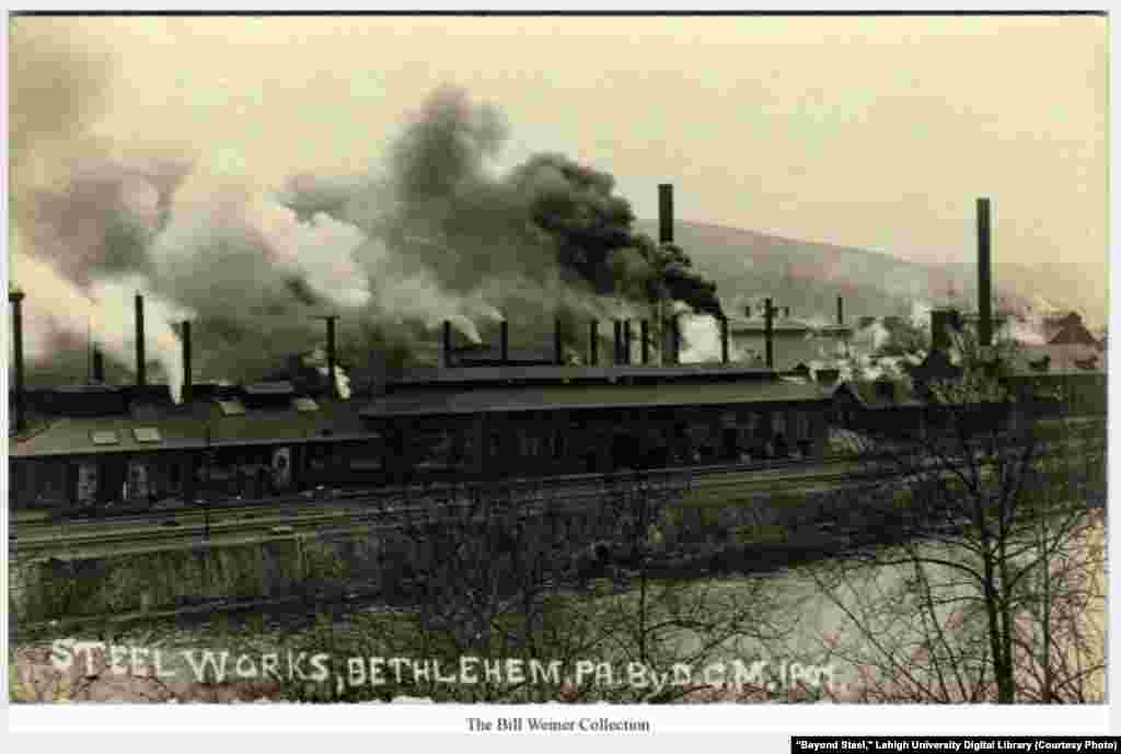 View of Bethlehem Steel plant with Lehigh River and railroad tracks in foreground and South Mountain in background, Bethlehem, Pa., early 1900s.