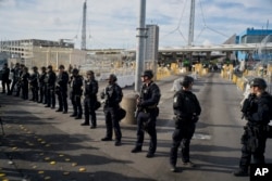 U.S. Customs and Border Protection agents stand guard at the San Ysidro port of entry on the U.S.-Mexico border, seen from Tijuana, Mexico, Nov. 22, 2018.
