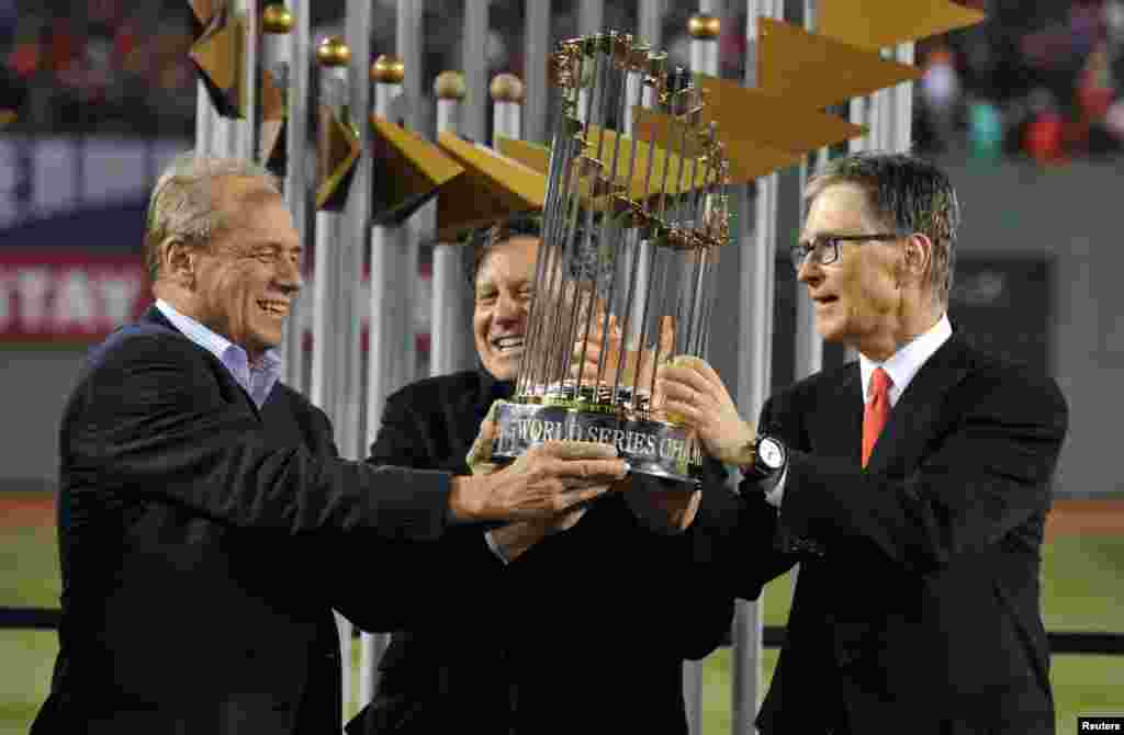 Oct 30, 2013; Boston, MA, USA; Boston Red Sox owners including John Henry (right) and Larry Lucchino (left) and Tom Werner (middle) hold the World Series championship trophy together after game six of the MLB baseball World Series against the St. Louis Ca