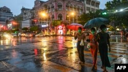 မိုးရွာနေချိန် နှာခေါင်းစည်းတပ် သွားလာနေသော လမ်းသွားလမ်းလာတချို့ကို ရန်ကုန်မြို့မှာတွေ့ရ။ (ဇွန် ၁၄၊ ၂၀၂၀)