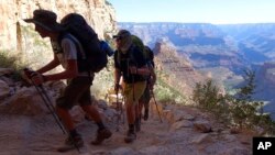 FILE - In this July 27, 2015, file photo, hikers head out of the Grand Canyon along the Bright Angel Trail at Grand Canyon National Park, Arizona.