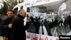 A man cries next to a poster with an image of Chokri Belaid, a prominent Tunisian opposition politician who was shot dead, Tunis February 7, 2013.