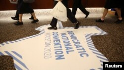 FILE - Hotel staff walk near a floor banner advertising the City of Houston's bid to host the 2020 Democratic National Convention during the (DNC) Summer Meeting in Chicago, Illinois, U.S., Aug. 23, 2018. Milwaukee has been selected for the convention.