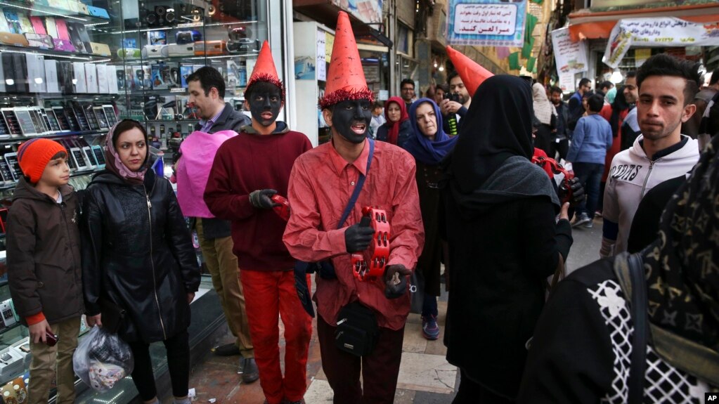 Iranian youths, wearing red clothes and black makeup as a symbol of the Iranian New Year, sing and play tambourine at Tajrish square in northern Tehran, Iran, ahead of the Iranian New Year, or Nowruz, meaning "new day," March 18, 2017.