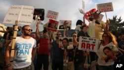 Lebanese activists hold pictures of Lebanese Cabinet ministers and various anti-government signs during a protest against the ongoing trash crisis, in downtown Beirut, Lebanon, Aug. 22, 2015.