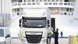 A police officer talks to a truck driver who left a ferry arriving from Italy to Split, Croatia, March 11, 2020. REUTERS/Antonio Bronic