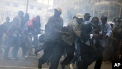 Anti-government protestors run from tear gas in Senegal's capital Dakar, February 15, 2012