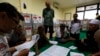 Election commission official Dedi Saidi, left, reads a document stating the number of votes collected in ballot boxes, at Bendungan Hilir, Jakarta, July 10, 2014. 