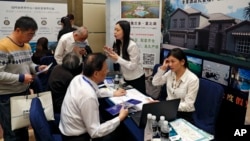 Chinese visitors seek information of the U.S. government's EB-5 visa program at the exhibitor booths in a Invest in America Summit, a day after an event promoting EB-5 investment in a Kushner Companies development was held at a hotel in Beijing, May 7, 2017.