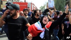 Iraqis grieve during the funeral procession of bomb victim, Akram Hadi, 24, who was killed in a massive truck bomb attack in the Karada neighborhood of Baghdad, Iraq, July 5, 2016. 