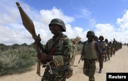 FILE - African Union Mission in Somalia (AMISOM) peacekeepers from Burundi patrol after fighting between insurgents and government soldiers erupted on the outskirts of Mogadishu.