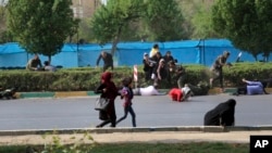 پریڈ میں فائرنگ کے دوران عام شہری جان بچانے کے لیے بھاگ رہے ہیں۔