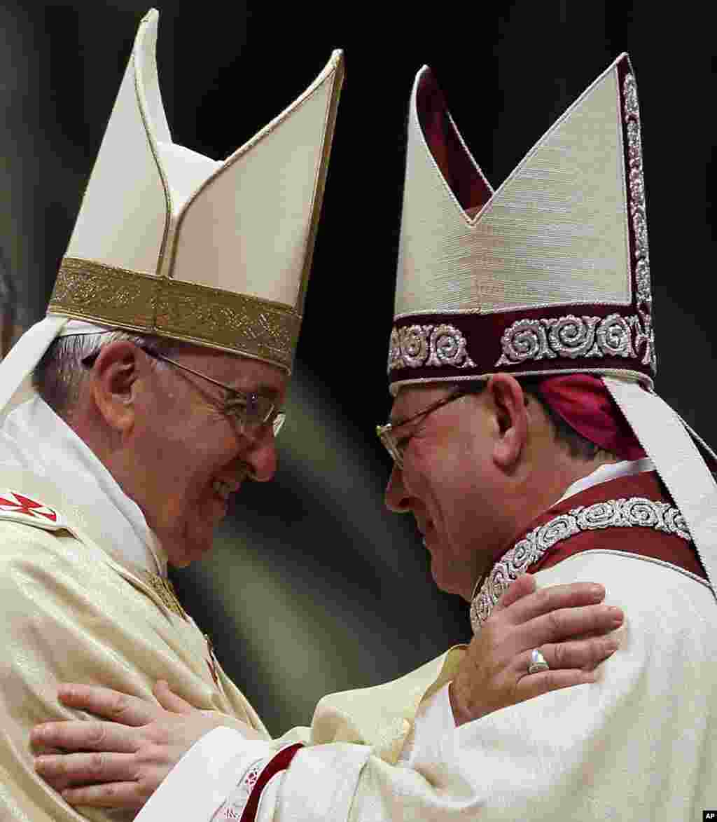 Mons. Fabio Fabene, right, is embraceed by Pope Francis during his Episcopal Ordination, at the Vatican.