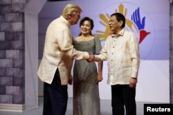 美国总统川普身穿菲律宾服装在马尼拉抵达东盟晚宴场所，和菲律宾总统杜特尔特握手（2017年11月12 日）