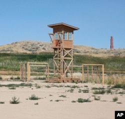 A replica of one of the camp’s watch towers in the exact place where it once stood. The smoke stack of the hospital is in the background.