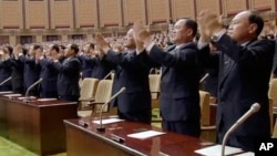 In this image made from video released April 11, 2017, by North Korean broadcaster KRT, officials stand and applaud as North Korean leader Kim Jong Un presides over parliament in Pyongyang, North Korea.