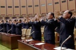 Para pejabat berdiri dan bertepuk tangan saat pemimpin Korea Utara Kim Jong-un memimpin sidang parlemen di Pyongyang, Korea Utara, 11 April 2017. (KRT videograb via AP)