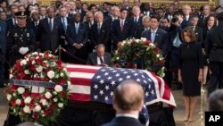 Predsedavajući Predstavničkog doma Pol Rajan, u sredini, i liderka manjine u Domu, Nensi Pelosi (desno) odaju počast pored zastavom prekrivenog kovčega sa posmrtnim ostacima senatora Džona Mekejna, 31. avgusta 2018, na Kapitol hilu u Vašingtonu.