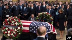 Speaker of the House Paul Ryan, center, and House minority leader Nancy Pelosi, right, pay their respects before the flag-draped coffin holding the remains of Sen. John McCain, Aug. 31, 2018, at the U.S. Capitol in Washington.