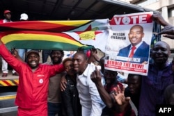 Supporters of MDC (Movement for Democratic Change Alliance) leader and opposition presidential candidate cheer outside the MDC headquarters in Harare, on July 31, 2018.