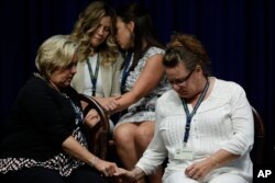 Victims and relatives of victims of clergy sexual abuse react as Pennsylvania Attorney General Josh Shapiro speaks during a news conference at the Pennsylvania Capitol in Harrisburg, Pa., Aug. 14, 2018.