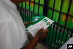 A member of military-backed Union Solidarity and Development Party holds leaflets promoting a candidate of USDP during an election campaign in Mandalay, the second largest city in Myanmar, Oct. 18, 2015.