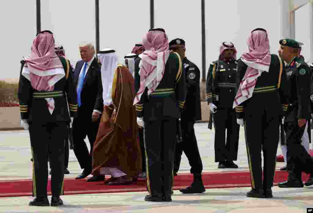Le président Donald Trump, à l&rsquo;arrière, et le roi saoudien Salman marchent au milieu d&rsquo;une haie d&rsquo;honneur de la garde royale à l&rsquo;aéroport international roi Khalid, Ryad 20 mai 2017.