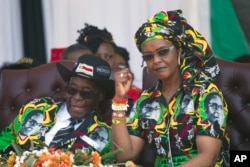 FILE - Zimbabwean first lady Grace Mugabe, right, is seen during better times with her husband, President Robert Mugabe, at a rally in Gweru, Zimbabwe, Sept, 1, 2017.