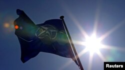 FILE - A NATO flag flies at the Alliance headquarters in Brussels, March 2, 2014.