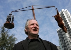 资料照：创作国殇之住的丹麦雕塑家高志活（Jens Galschiot）在香港维多利亚公园内树立的他的雕塑作品“疯牛病”前接受记者采访。（2005年12月15日）