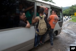 Honduran migrants get a free ride from a driver during their caravan to the U.S., in Chiquimula, Guatemala, Oct. 16, 2018. U.S. President Donald Trump threatened on Tuesday to cut aid to Honduras if it didn't stop the impromptu caravan of migrants.