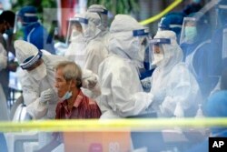 A health worker collects sample for new coronavirus testing from a man at the newly locked down area in Kuala Lumpur, Malaysia, on Friday, May 15, 2020.