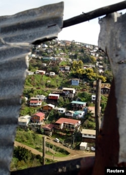 A low-income neighborhood is seen through the roof of a shanty on a hillside in the Chilean coastal city of Valparaiso on June 29, 2005.