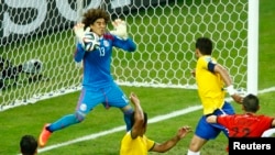 Penjaga gawang Meksiko, Guillermo Ochoa, menahan serangan tim Brazil dalam pertandingan Grup A (17/6). (Reuters/Mike Blake)