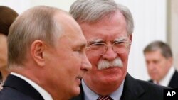 Russian President Vladimir Putin, left, and U.S. President Donald Trump's National Security Adviser John Bolton are seen during their meeting in the Kremlin, in Moscow, Russia, Oct. 23, 2018.