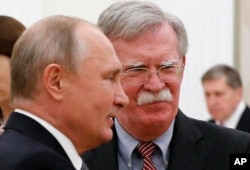 Russian President Vladimir Putin, left, and U.S. President Donald Trump's National Security Adviser John Bolton are seen during their meeting in the Kremlin, in Moscow, Russia, Oct. 23, 2018.